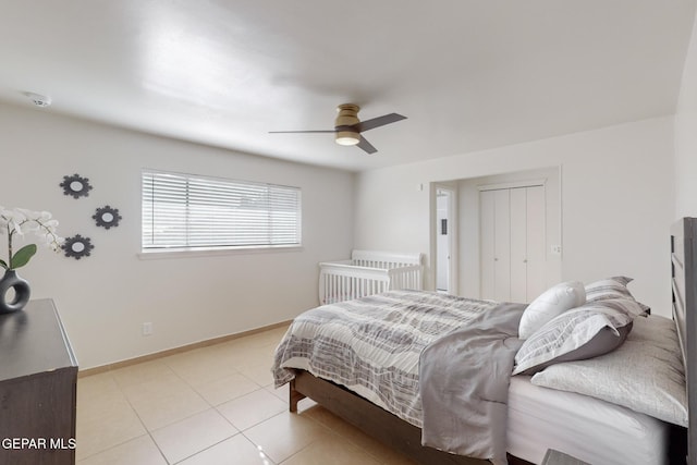 tiled bedroom with ceiling fan and a closet