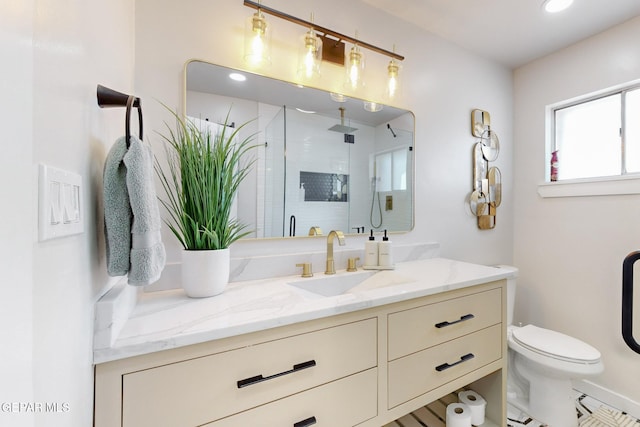 bathroom featuring vanity, an enclosed shower, and toilet