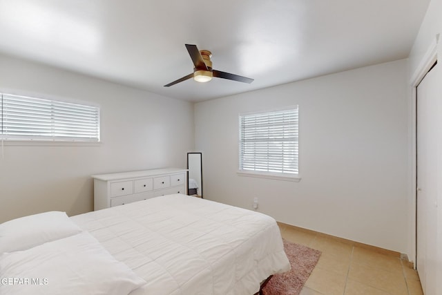 tiled bedroom with a closet and ceiling fan