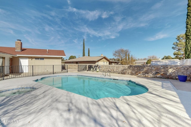 view of swimming pool with a patio and an outdoor hot tub