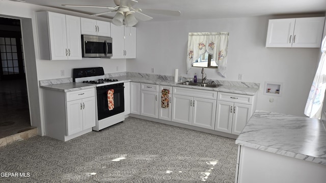 kitchen with sink, range with gas cooktop, and white cabinetry