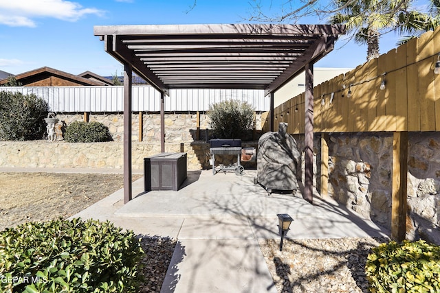 view of patio with area for grilling and a pergola