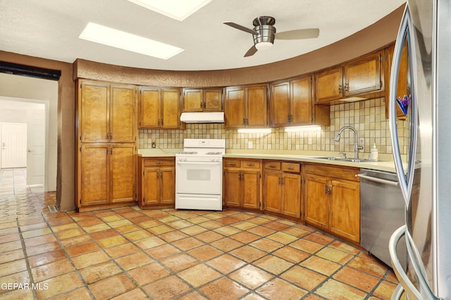 kitchen featuring backsplash, ceiling fan, sink, and appliances with stainless steel finishes