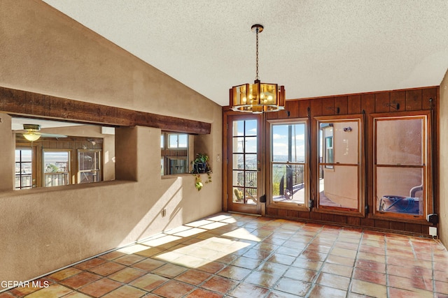 doorway to outside with a textured ceiling, ceiling fan with notable chandelier, vaulted ceiling, and wood walls