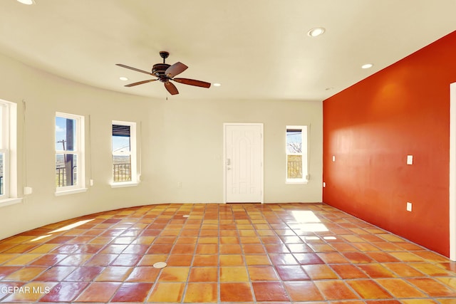 empty room with ceiling fan and light tile patterned floors