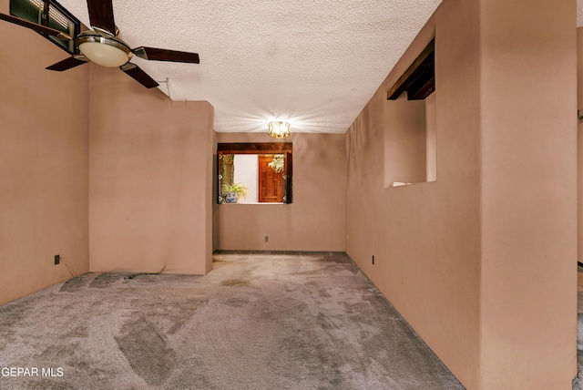 carpeted spare room featuring ceiling fan and a textured ceiling