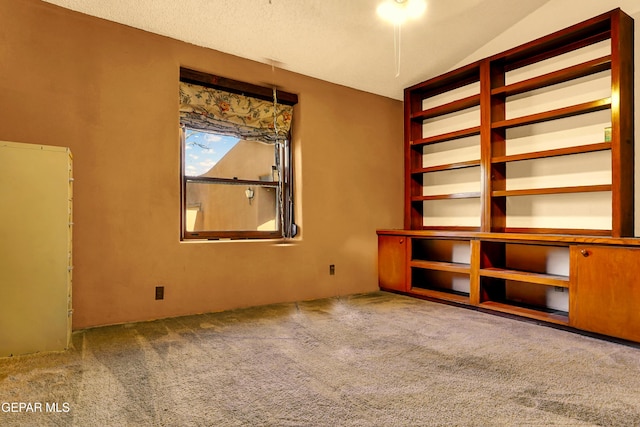 carpeted spare room featuring vaulted ceiling