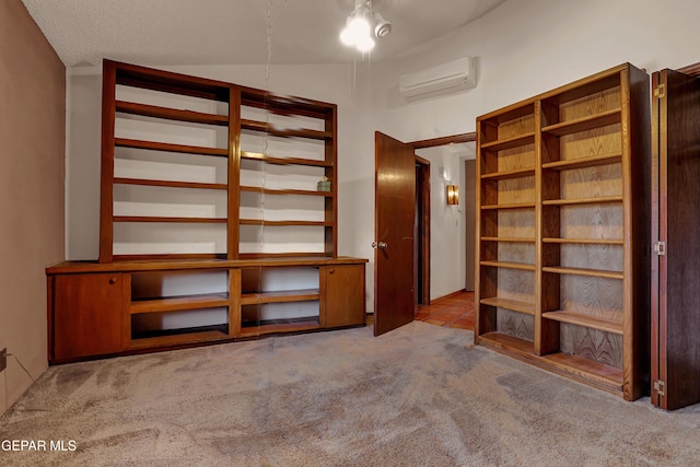 interior space featuring lofted ceiling, light colored carpet, and an AC wall unit