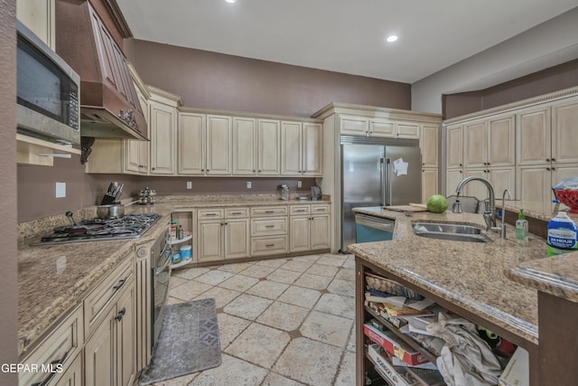 kitchen with light stone counters, sink, appliances with stainless steel finishes, and cream cabinets