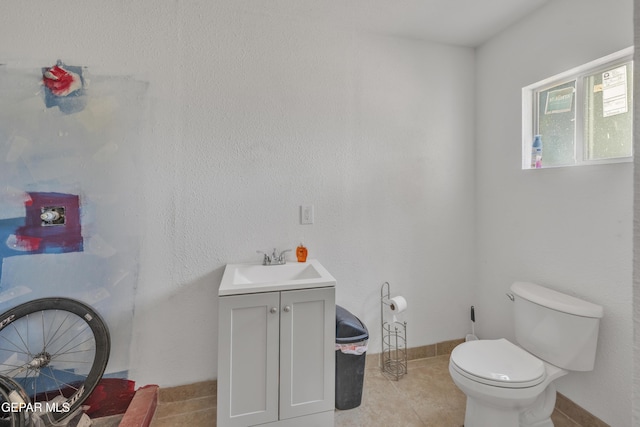 bathroom with toilet, vanity, and tile patterned floors