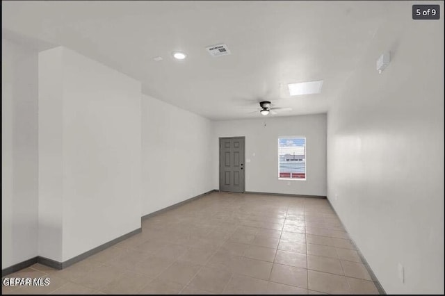 tiled spare room with ceiling fan