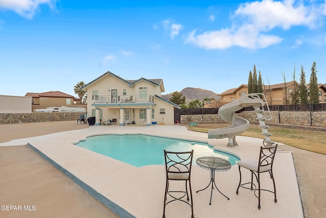 view of pool with a mountain view, a patio area, and a water slide