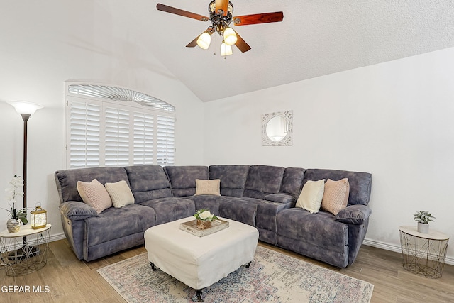 living room with a textured ceiling, ceiling fan, hardwood / wood-style floors, and lofted ceiling