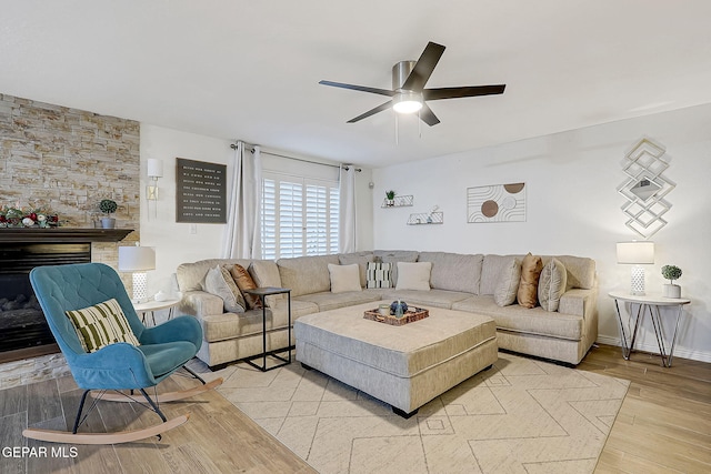 living room featuring a fireplace, light wood-type flooring, and ceiling fan