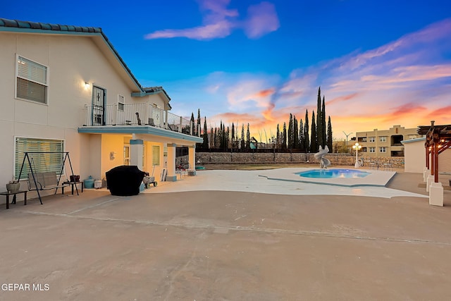 pool at dusk with a patio and a water slide