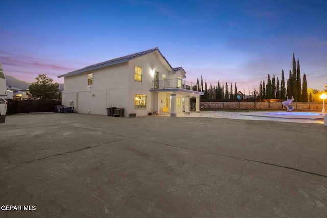 property exterior at dusk with a balcony