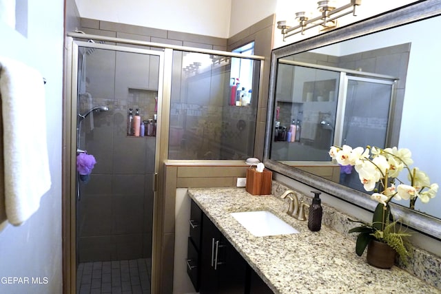 bathroom with a shower with door and vanity