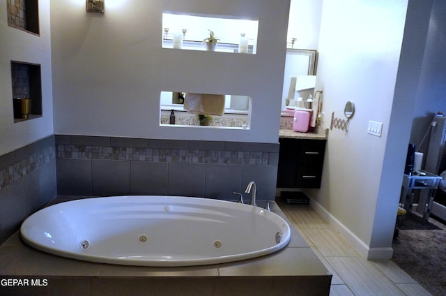 bathroom with vanity and tiled bath