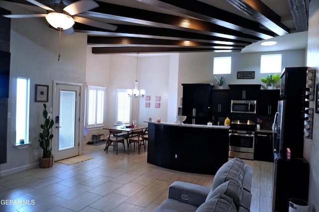 living room featuring beam ceiling, a wealth of natural light, and ceiling fan with notable chandelier