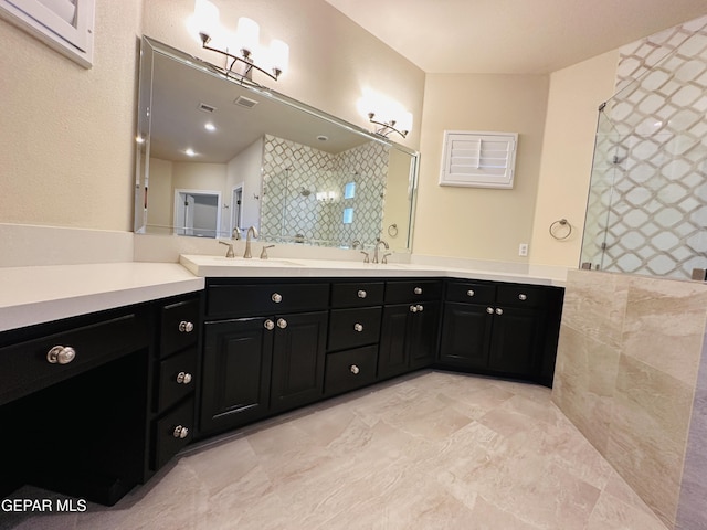 bathroom with a tile shower and vanity