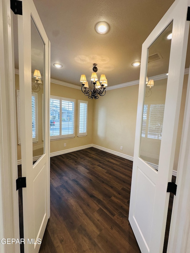 unfurnished dining area featuring ornamental molding, dark hardwood / wood-style floors, and a notable chandelier