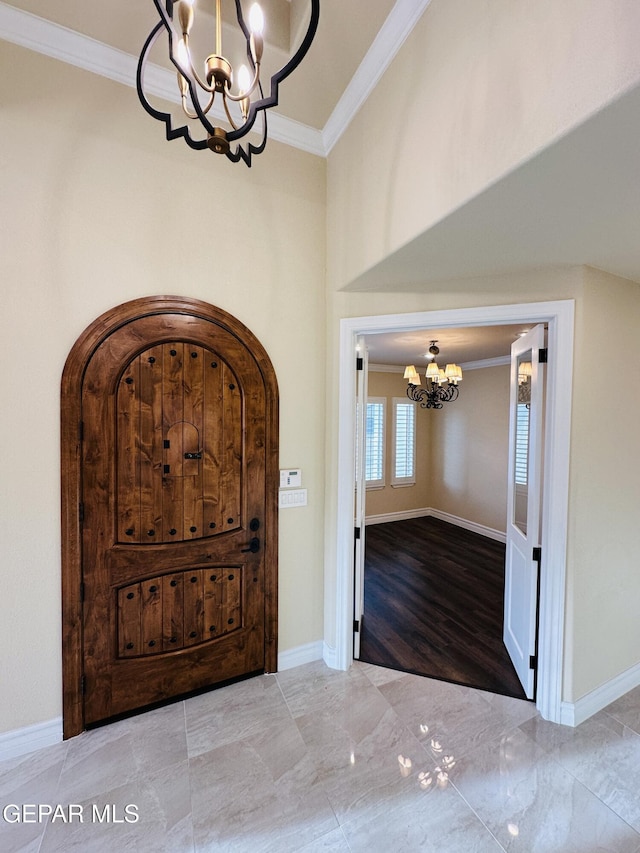 foyer with ornamental molding and a notable chandelier