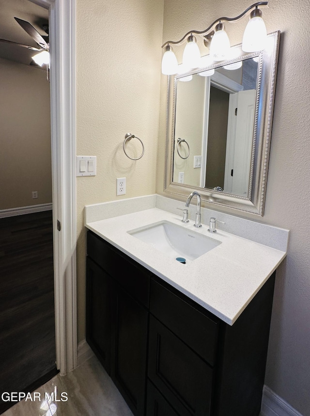 bathroom featuring ceiling fan, hardwood / wood-style floors, and vanity