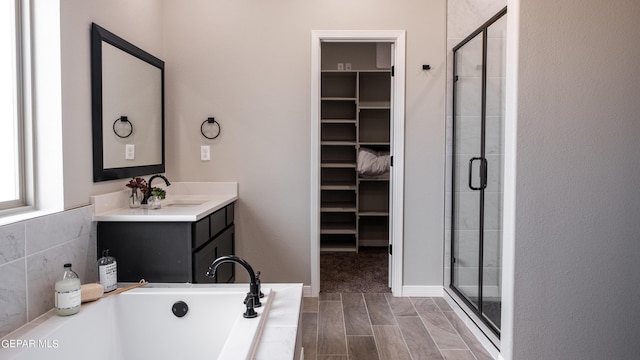 bathroom featuring vanity and independent shower and bath