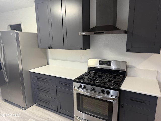 kitchen featuring wall chimney exhaust hood, appliances with stainless steel finishes, light countertops, and light wood-style flooring