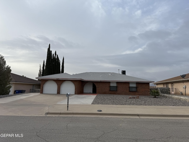 view of front facade featuring a garage, concrete driveway, and brick siding