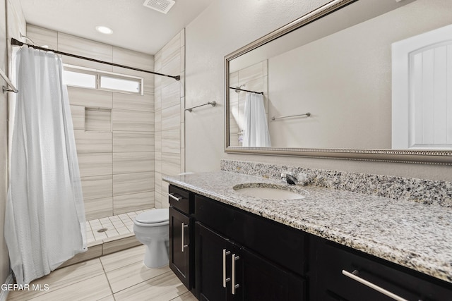 bathroom with tile patterned flooring, vanity, toilet, and curtained shower