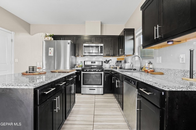 kitchen featuring light tile patterned floors, sink, appliances with stainless steel finishes, and tasteful backsplash