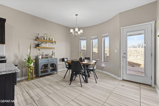 dining space featuring light tile patterned floors, a wealth of natural light, and a chandelier