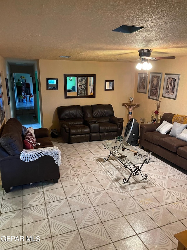 living room featuring ceiling fan and a textured ceiling