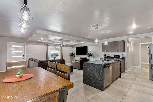 kitchen featuring dishwasher, a kitchen island with sink, a raised ceiling, sink, and dark brown cabinets