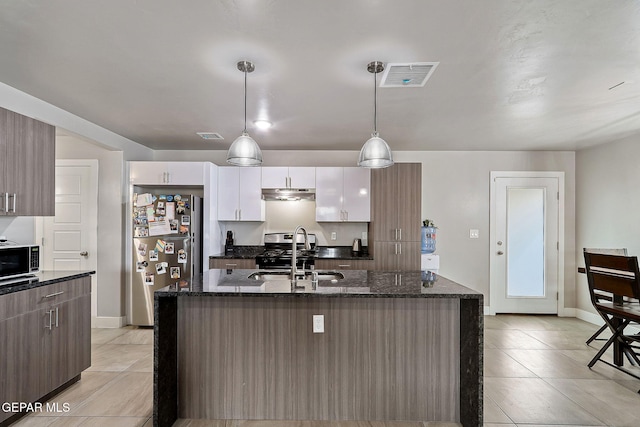 kitchen featuring white cabinetry, sink, stainless steel appliances, an island with sink, and decorative light fixtures