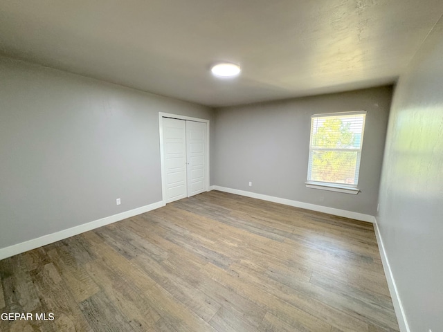 unfurnished bedroom featuring a closet and wood-type flooring