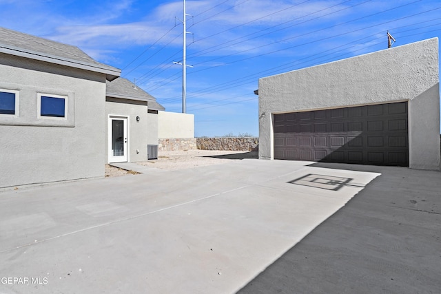 view of patio / terrace with central AC and a garage