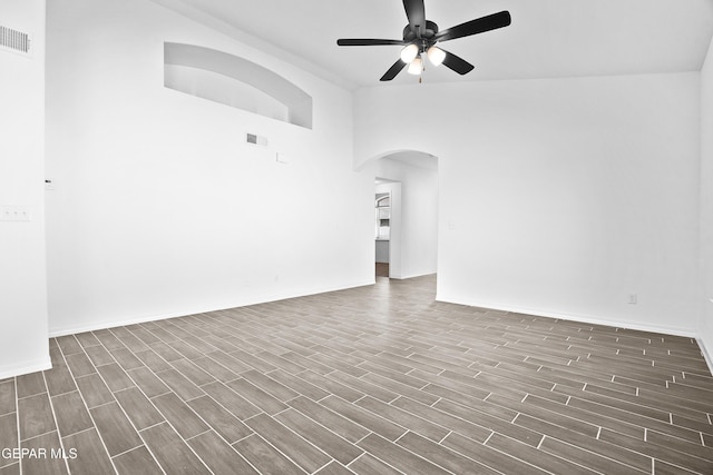 unfurnished living room with ceiling fan and a towering ceiling