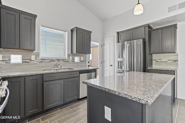 kitchen featuring decorative backsplash, sink, decorative light fixtures, and appliances with stainless steel finishes