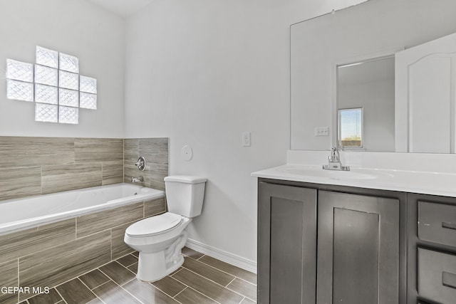 bathroom with vanity, toilet, and tiled tub