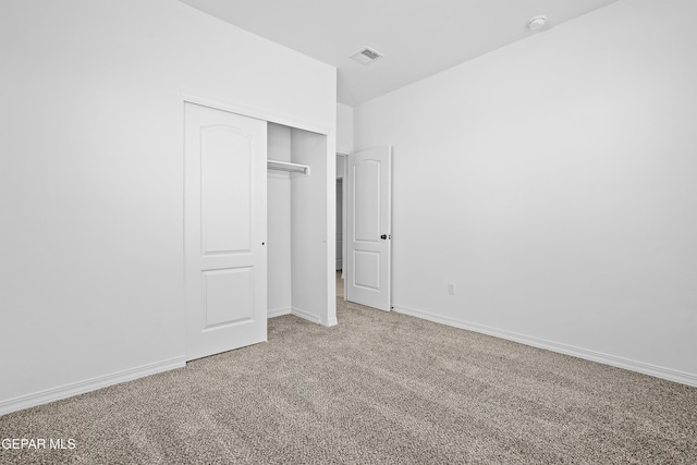 unfurnished bedroom featuring carpet and a closet