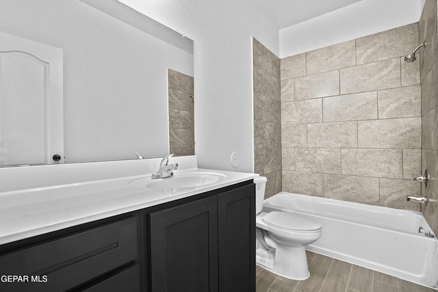 full bathroom featuring toilet, vanity, and tiled shower / bath