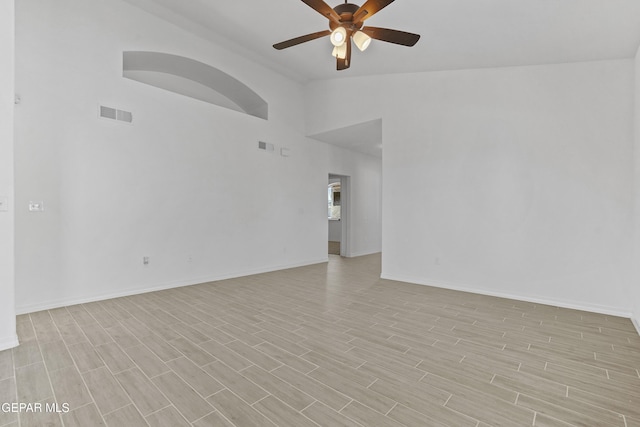 empty room with light hardwood / wood-style flooring, ceiling fan, and lofted ceiling