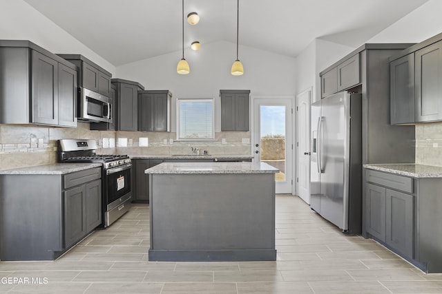 kitchen featuring gray cabinetry, sink, stainless steel appliances, decorative light fixtures, and lofted ceiling