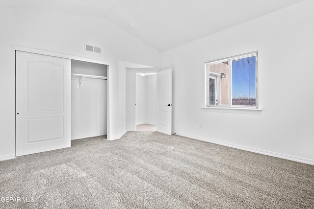 unfurnished bedroom featuring carpet, lofted ceiling, and a closet