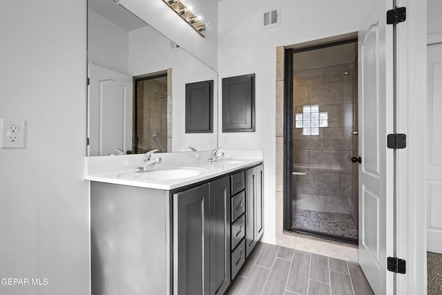 bathroom with vanity and tiled shower