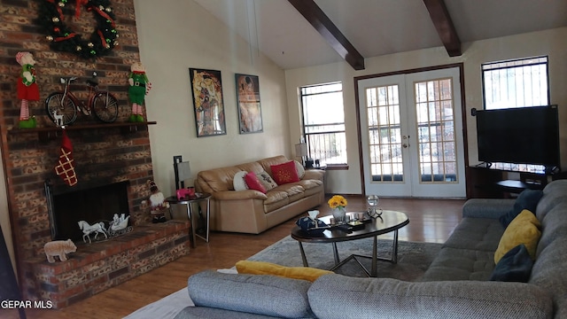 living room with a brick fireplace, vaulted ceiling with beams, french doors, and wood finished floors