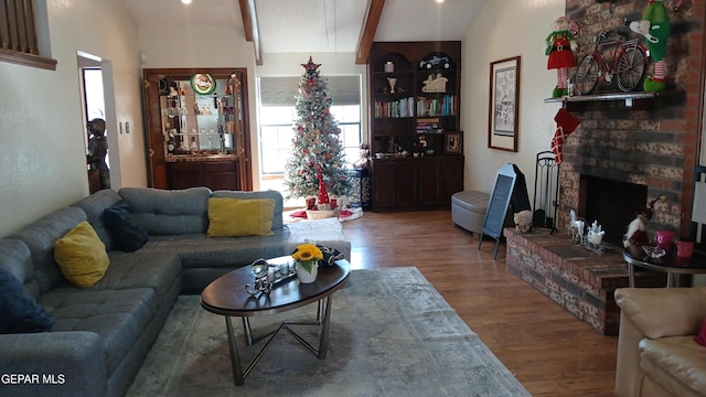 living room with hardwood / wood-style floors, lofted ceiling with beams, and a fireplace