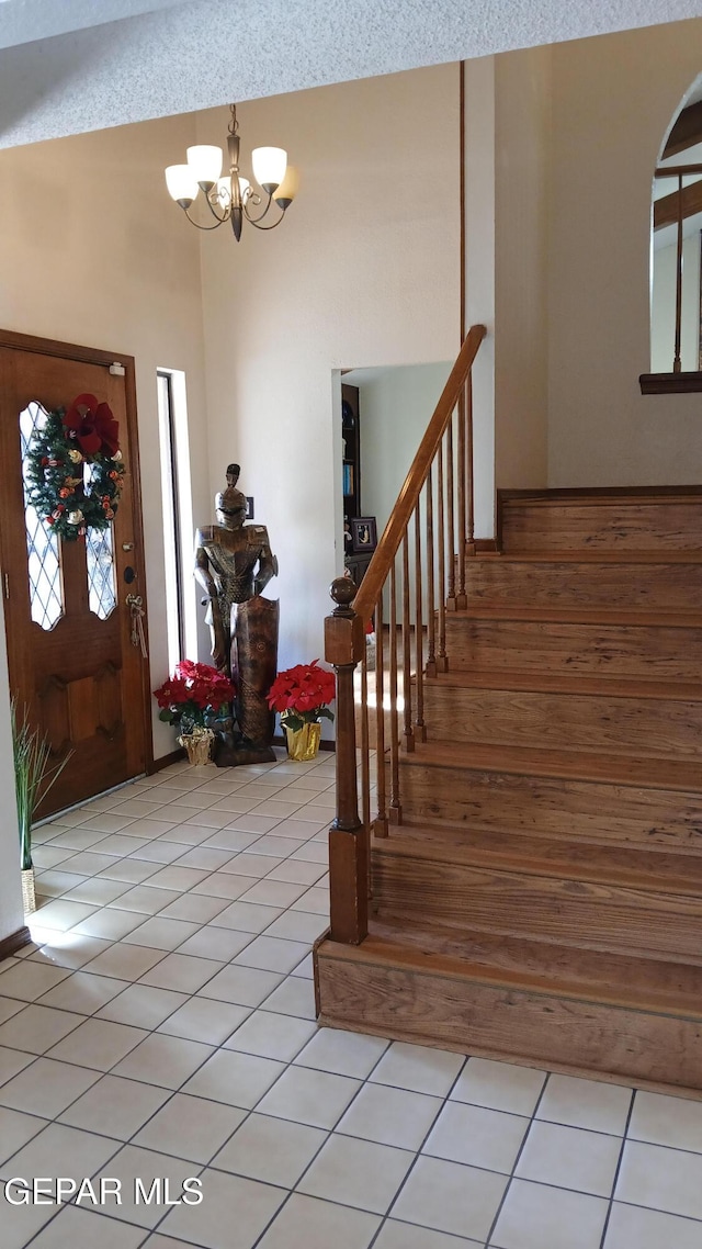 foyer entrance featuring tile patterned flooring and an inviting chandelier